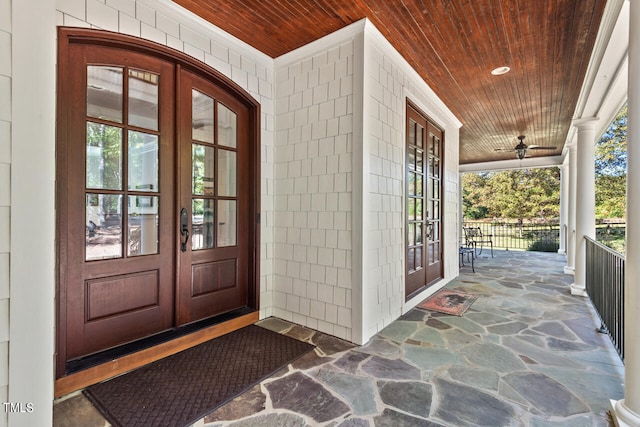 view of exterior entry with covered porch and french doors