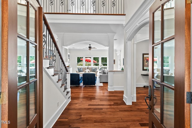 foyer entrance featuring french doors, ornate columns, dark hardwood / wood-style floors, ornamental molding, and ceiling fan