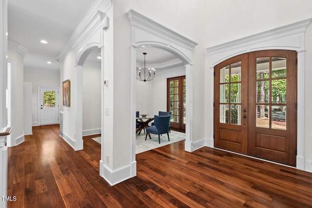 entryway featuring french doors, crown molding, an inviting chandelier, and dark hardwood / wood-style flooring