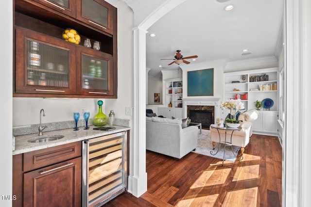 bar featuring dark hardwood / wood-style floors, wine cooler, sink, crown molding, and light stone countertops