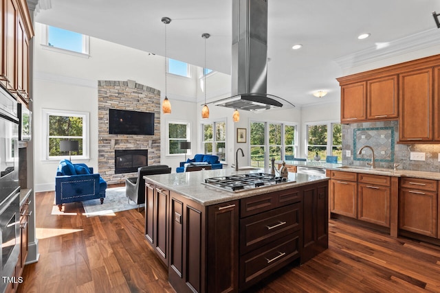 kitchen featuring a kitchen island with sink, stainless steel appliances, dark wood-type flooring, sink, and light stone counters