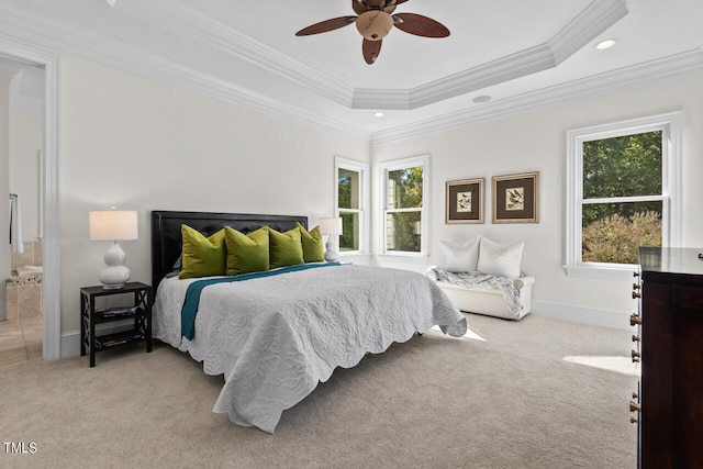 carpeted bedroom with crown molding, ensuite bathroom, a raised ceiling, and ceiling fan