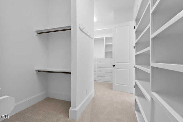 walk in closet featuring light colored carpet