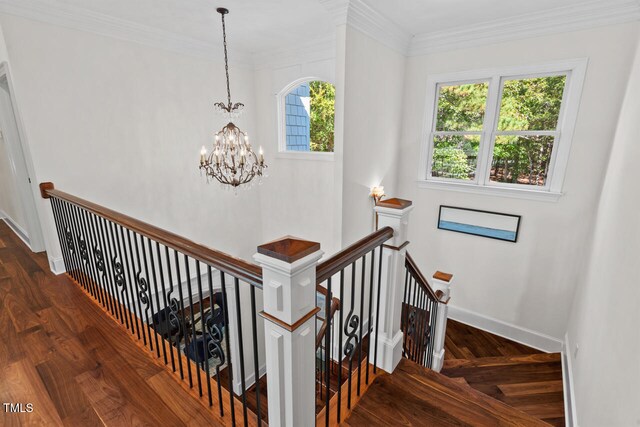 stairway with crown molding, a notable chandelier, and wood-type flooring