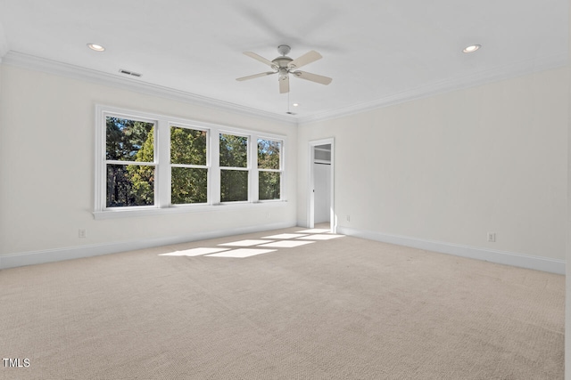 spare room featuring light carpet, ornamental molding, and ceiling fan