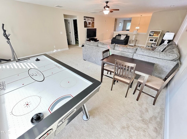 playroom featuring light carpet and ceiling fan with notable chandelier