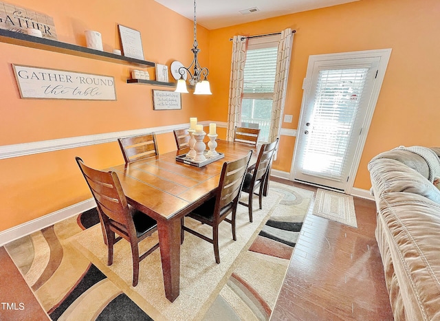 dining area featuring an inviting chandelier and hardwood / wood-style floors