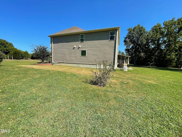 view of side of property with a yard and a sunroom