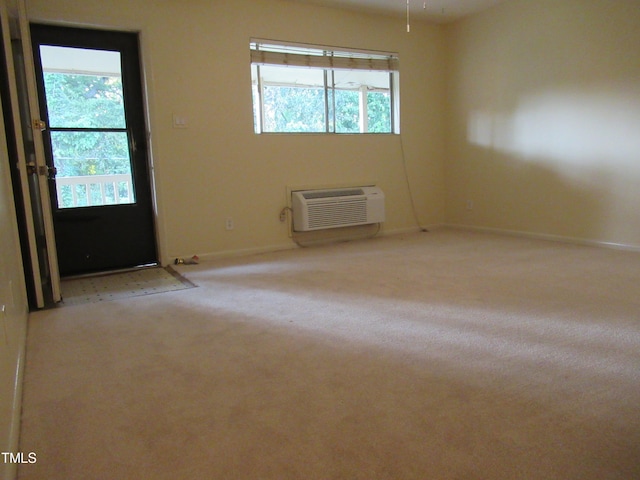 carpeted empty room featuring plenty of natural light and an AC wall unit