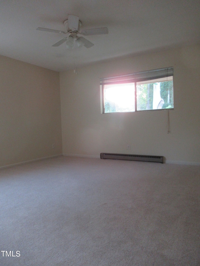 carpeted spare room with a baseboard heating unit and ceiling fan