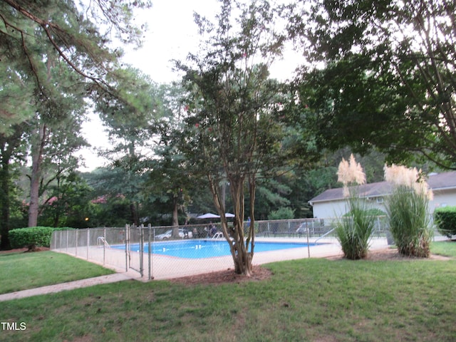 view of pool featuring a lawn