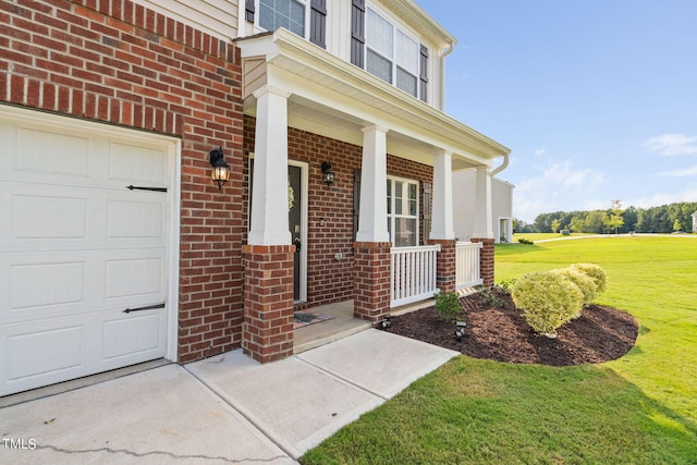 view of exterior entry with covered porch, a yard, and a garage