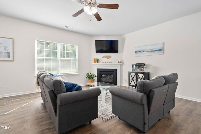 living room featuring ceiling fan and dark hardwood / wood-style flooring