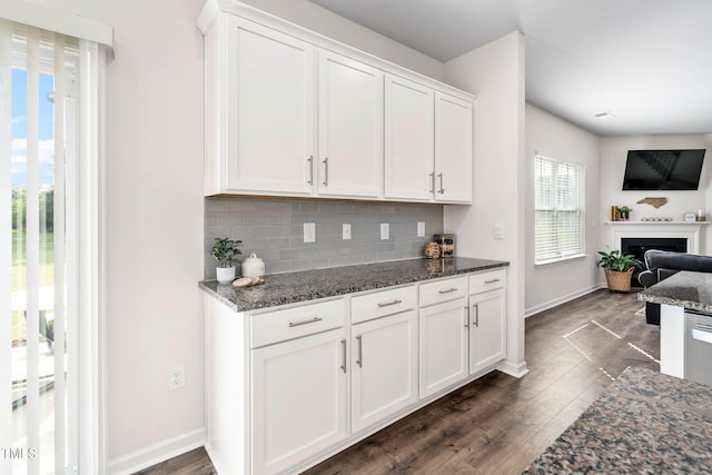 kitchen featuring dark wood-type flooring, white cabinetry, and dark stone counters