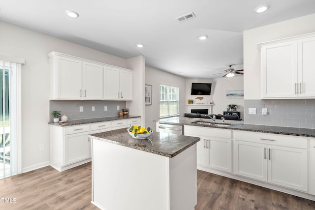 kitchen with white cabinetry, wood-type flooring, a center island, sink, and ceiling fan