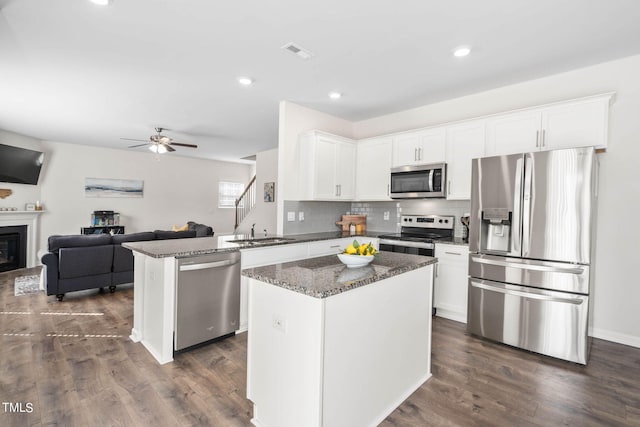 kitchen featuring appliances with stainless steel finishes, white cabinetry, kitchen peninsula, and ceiling fan