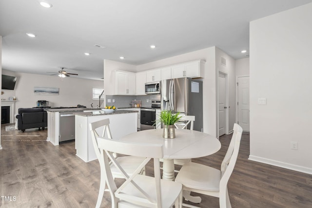 dining area with dark wood-type flooring and ceiling fan