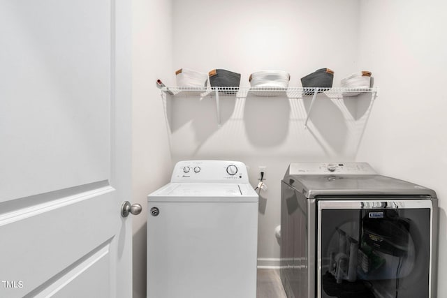 clothes washing area with independent washer and dryer and hardwood / wood-style flooring