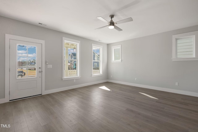 empty room featuring dark wood-type flooring and ceiling fan