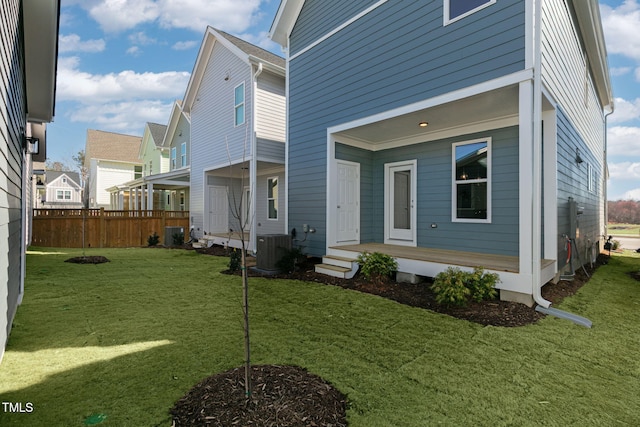 back of property featuring a yard and central AC