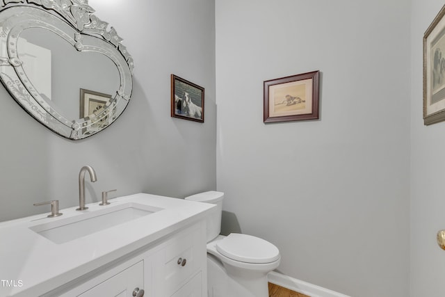 bathroom with vanity, toilet, and hardwood / wood-style floors