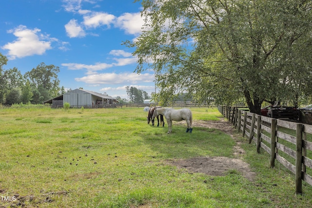 view of yard with an outdoor structure and a rural view