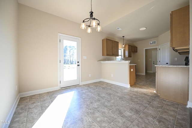 kitchen with kitchen peninsula, decorative light fixtures, and a notable chandelier