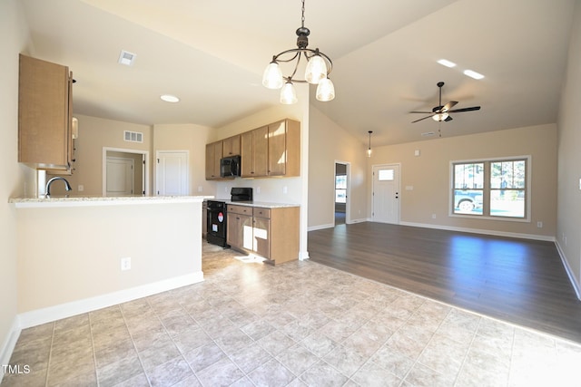 kitchen featuring kitchen peninsula, pendant lighting, vaulted ceiling, black appliances, and ceiling fan with notable chandelier