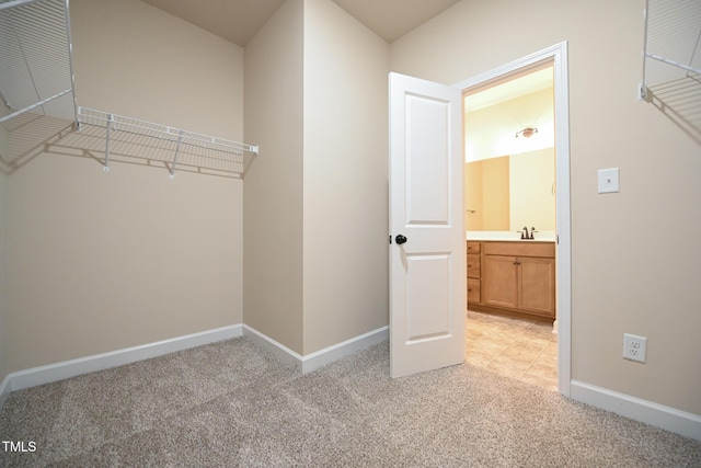 walk in closet featuring light carpet and sink