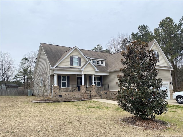 craftsman-style house featuring a garage, a front yard, a porch, and central air condition unit