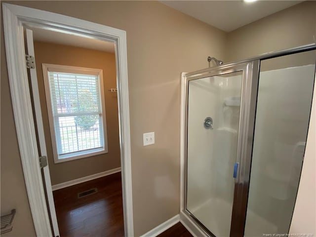 bathroom featuring a shower with shower door and hardwood / wood-style floors