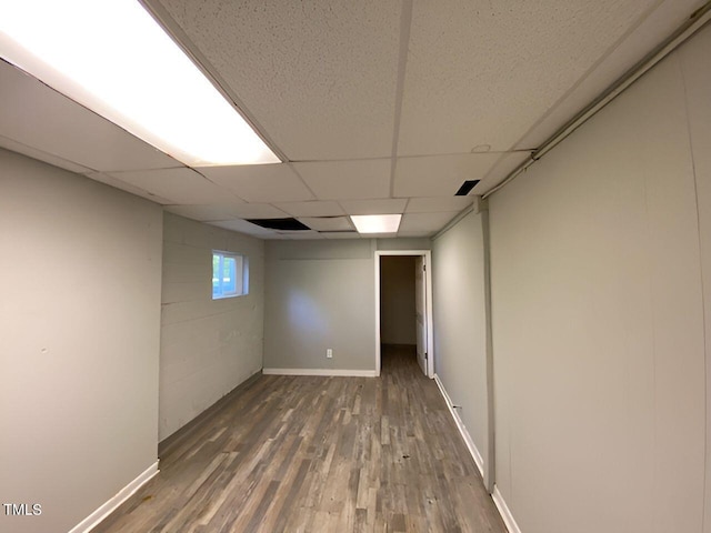 basement featuring a paneled ceiling and wood-type flooring