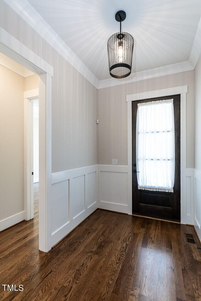 interior space with crown molding and dark hardwood / wood-style flooring