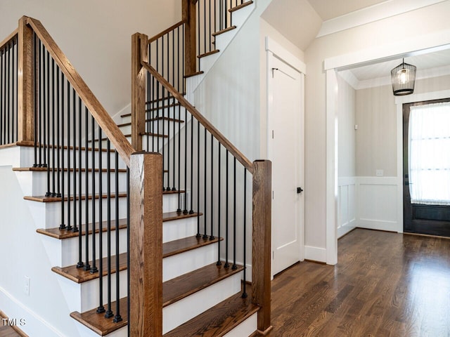 stairs with wood-type flooring and ornamental molding