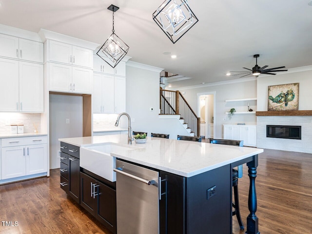 kitchen featuring dishwasher, an island with sink, hanging light fixtures, dark wood-type flooring, and white cabinets