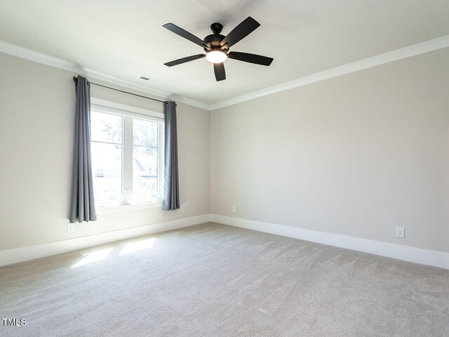 spare room featuring carpet flooring, ceiling fan, and ornamental molding