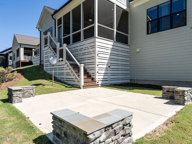 exterior space featuring a sunroom, a yard, and a patio