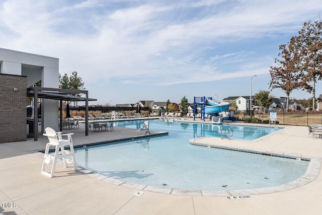 view of swimming pool with a water slide and a patio area