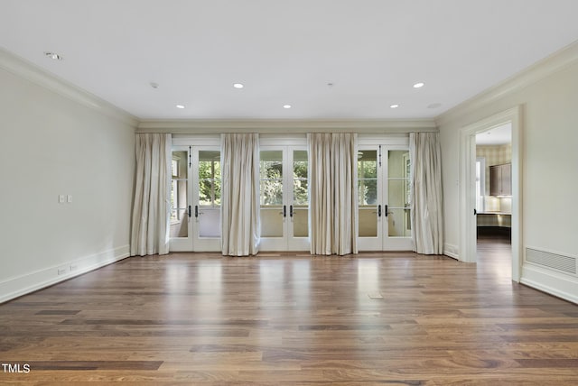 empty room featuring wood finished floors, recessed lighting, french doors, and ornamental molding