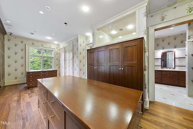 kitchen with visible vents, light wood-style flooring, crown molding, and wallpapered walls