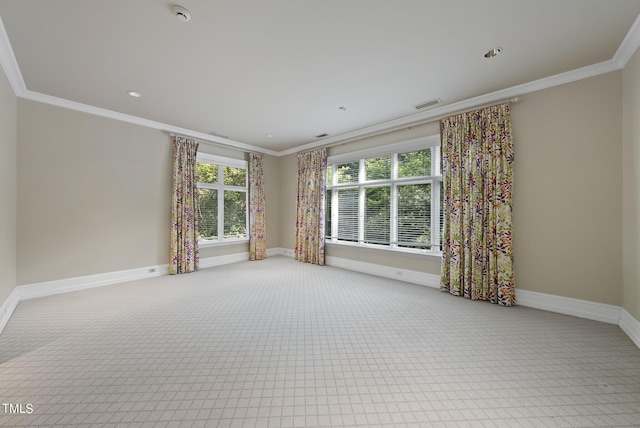 unfurnished room featuring crown molding, plenty of natural light, and baseboards