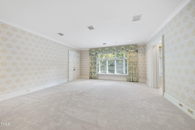 carpeted empty room featuring wallpapered walls, crown molding, baseboards, and visible vents