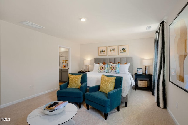 bedroom featuring light carpet and ensuite bathroom