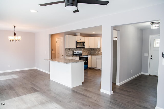 kitchen with ceiling fan with notable chandelier, light stone countertops, hardwood / wood-style floors, appliances with stainless steel finishes, and white cabinets