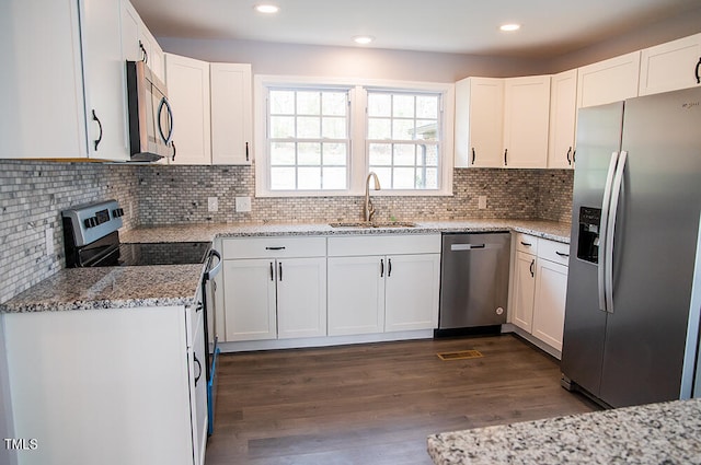 kitchen with appliances with stainless steel finishes, white cabinetry, sink, and dark hardwood / wood-style floors