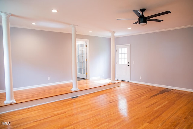 empty room with ornamental molding, light hardwood / wood-style flooring, and ornate columns