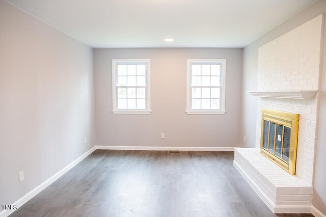 unfurnished living room with plenty of natural light, hardwood / wood-style floors, and a fireplace