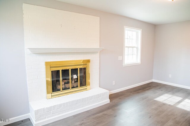 unfurnished living room featuring a fireplace and hardwood / wood-style flooring