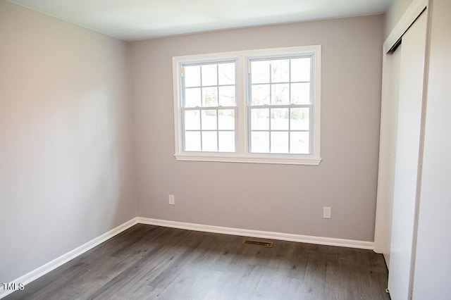 unfurnished bedroom featuring a closet and dark hardwood / wood-style floors