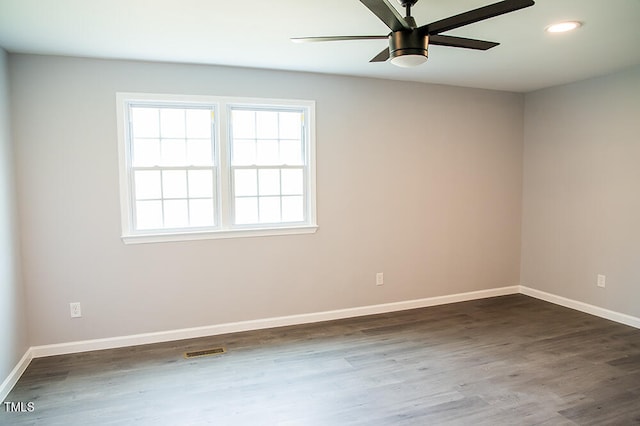 unfurnished room featuring dark wood-type flooring and ceiling fan